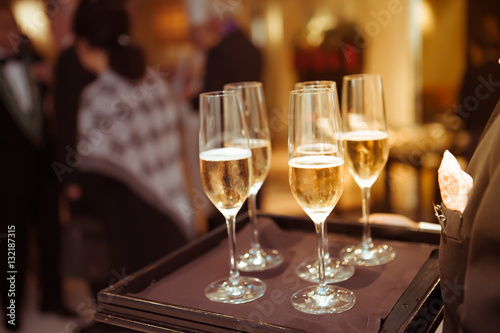 Blurry background waiter serving champagne to customer in restau