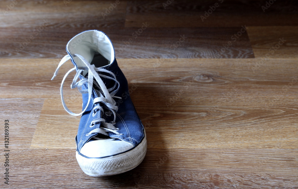 Classic blue and white sneaker, or trainer,or basketball boot on wooden background with space for text