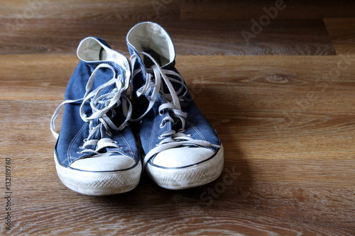 Pair of blue and white sneakers trainers boots on wooden background with space for text