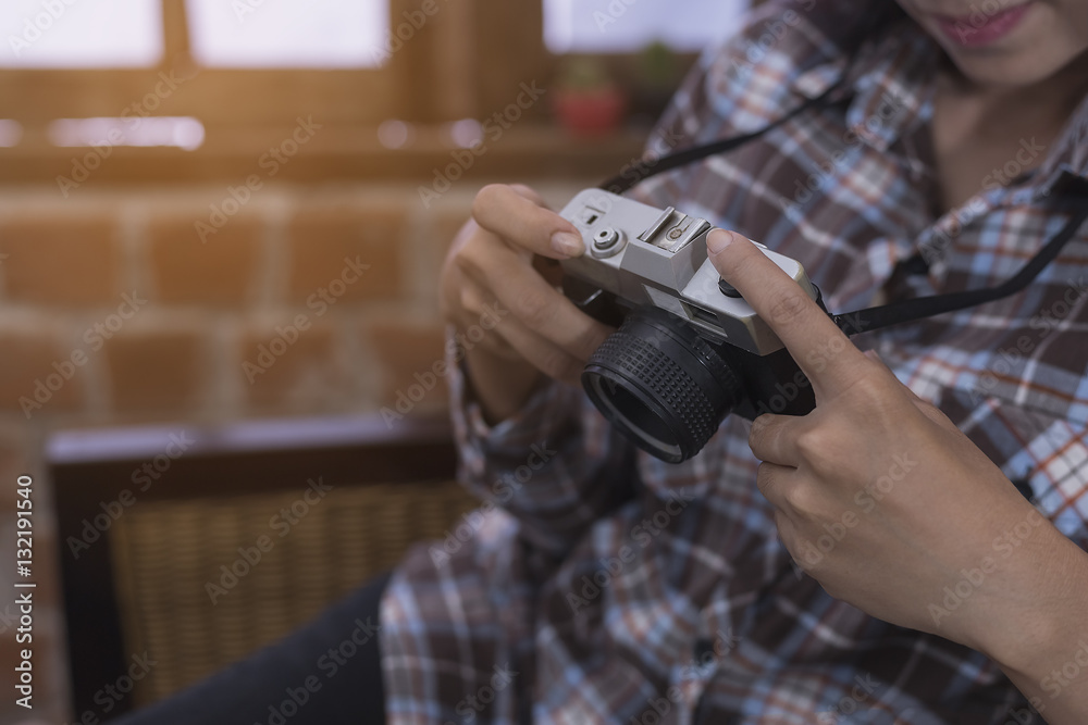 Portrait of hipster girl posing with retro camera wearing checke