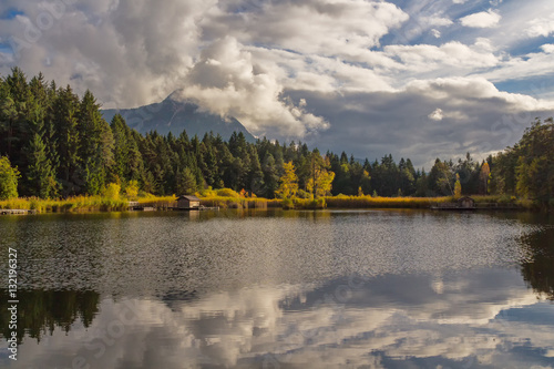 Fototapeta Naklejka Na Ścianę i Meble -  autumn colorful dolomites mountain peaks with blue sky reflecting in the lake