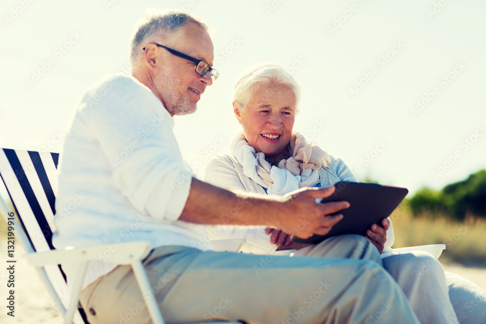 Obraz premium happy senior couple with tablet pc on summer beach
