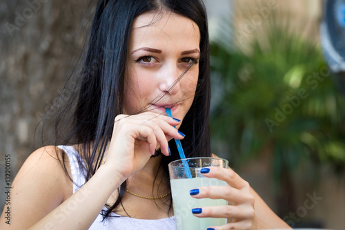 Woman drinking lemonade with a straw,sitting in a restaurant