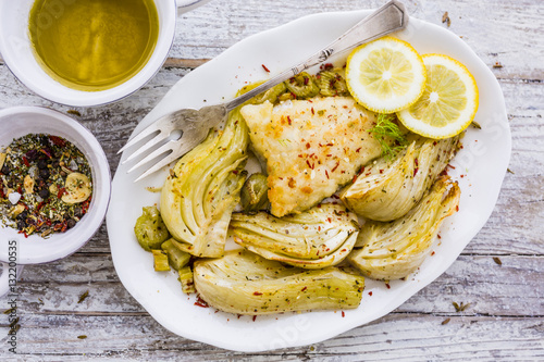 Baked fennel with herbs and olive oil served with fried fish.
