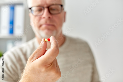 close up of old man hand with pill