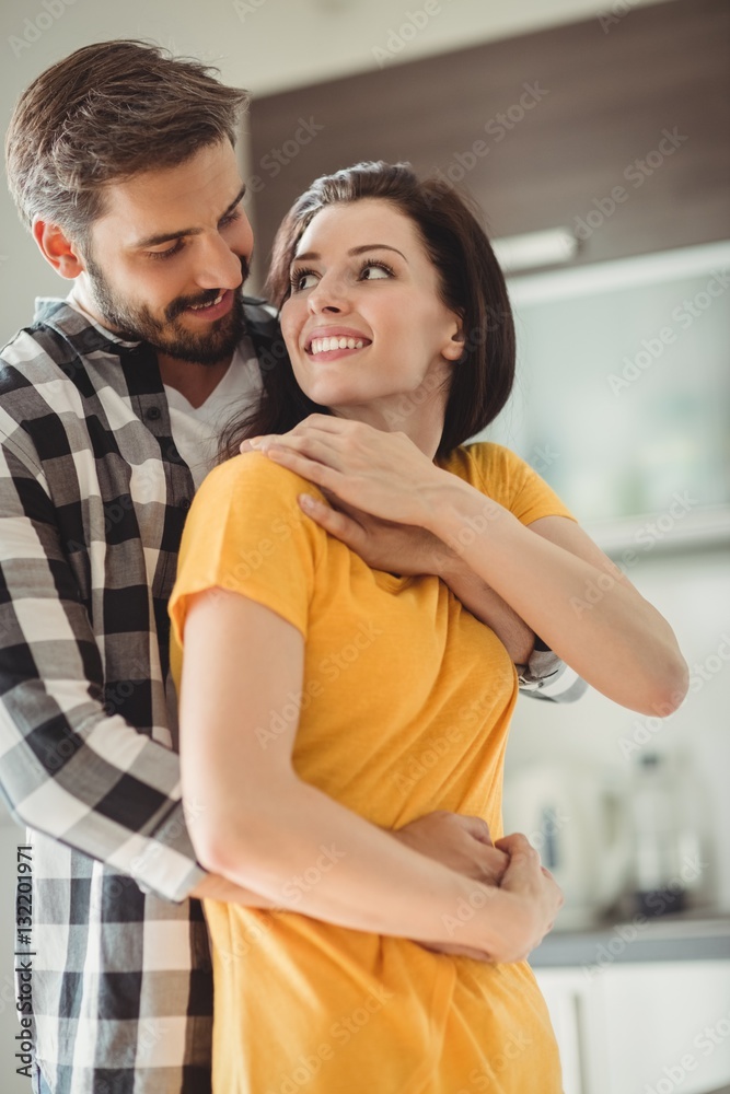 Fototapeta premium Portrait of happy couple embracing in kitchen 