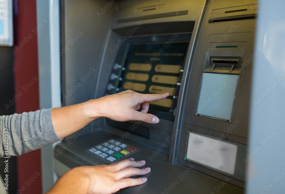 close up of hands choosing option on atm machine close up of hands choosing option on atm machine