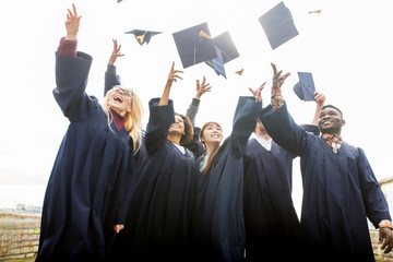 happy students throwing mortar boards up