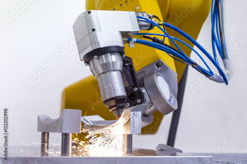 laser cutting of metal on robotic arm with sparks