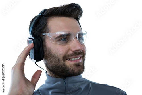 Man in protective glasses listening to headphones