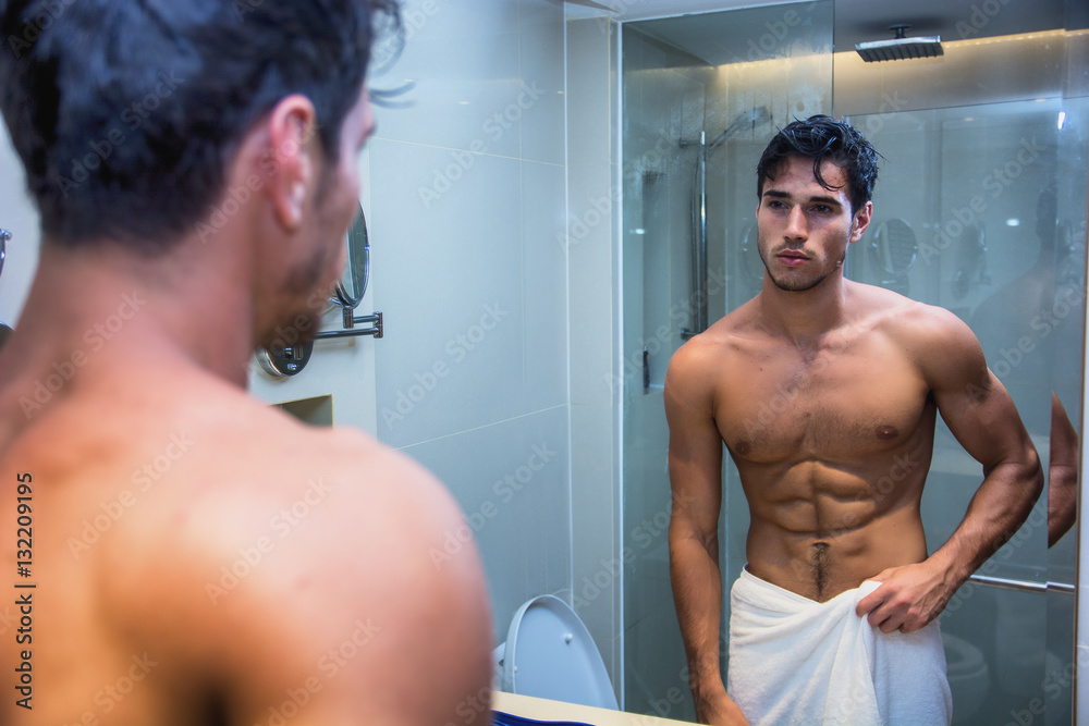 © theartofphoto - Shirtless muscular handsome young man looking at himself in bathroom mirror in the morning © theartofphoto - Shirtless muscular handsome young man looking at himself in bathroom mirror in the morning