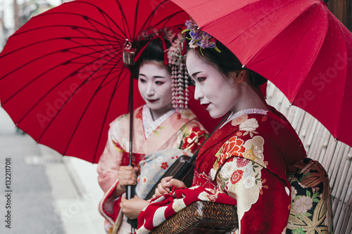  Maiko geishas walking on a street of Gion