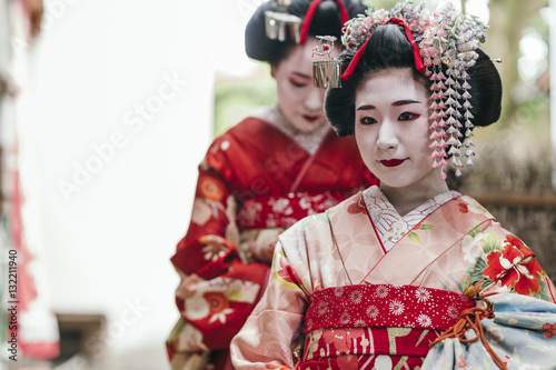  Maiko geishas walking on a street of Gion