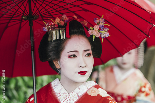  Maiko geishas walking on a street of Gion