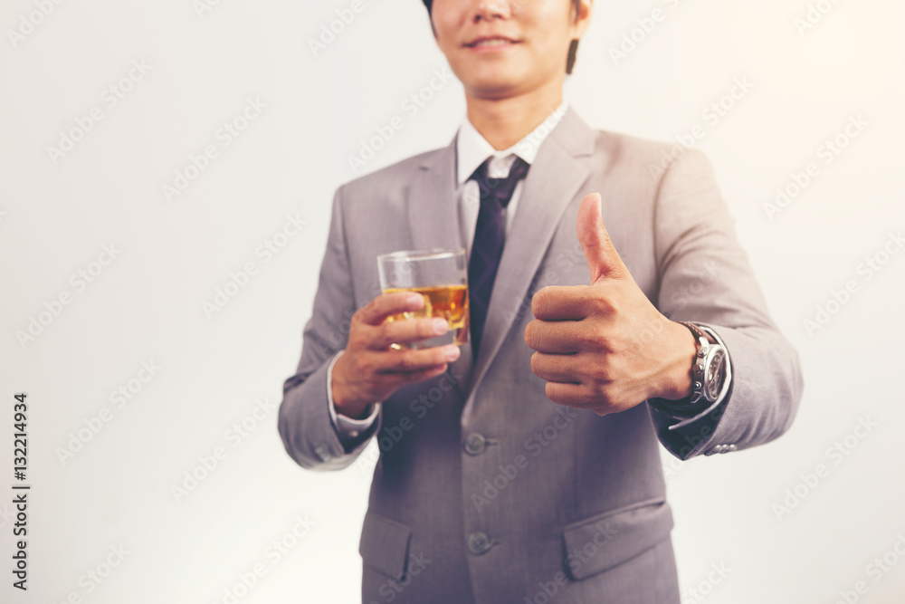 businessman holding a glass of whiskey and showing thumbs up. businessman holding a glass of whiskey and showing thumbs up.