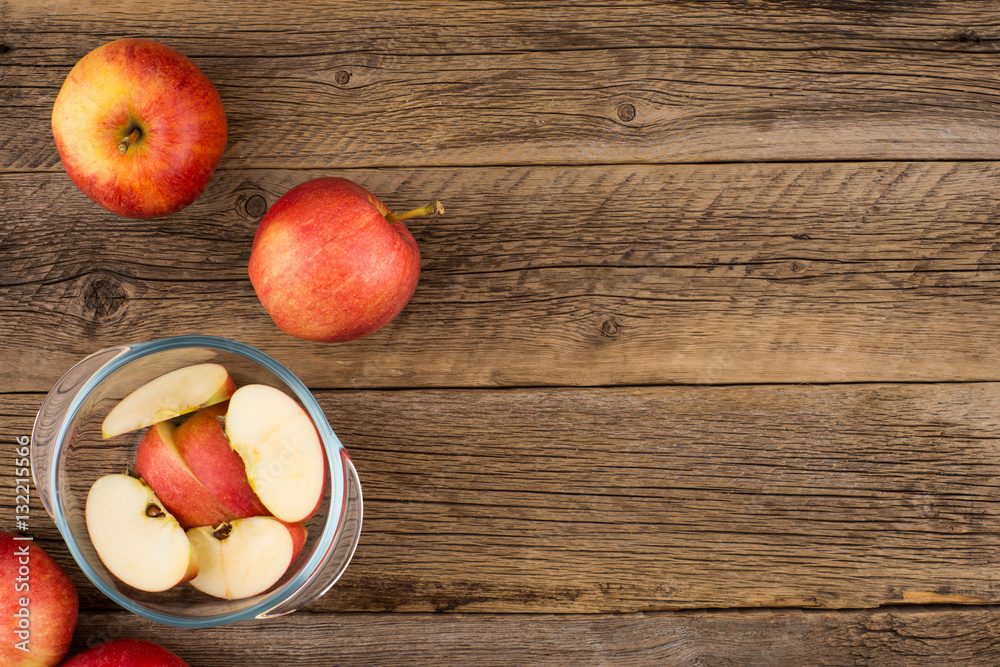 Sliced apples in a glass bowl on the old wooden table. Sliced apples in a glass bowl on the old wooden table.