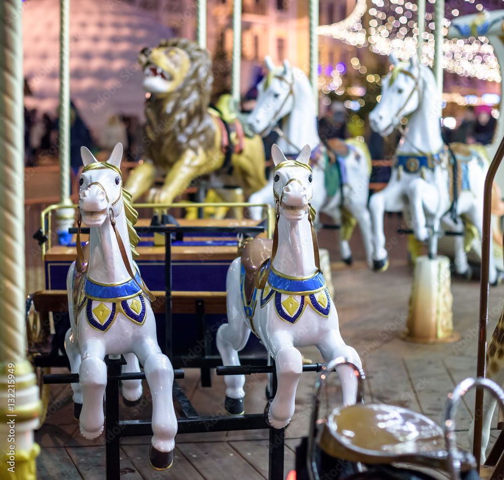 Old French carousel in a holiday park. Three horses and airplane on traditional fairground vintage . Merry-go-round with .