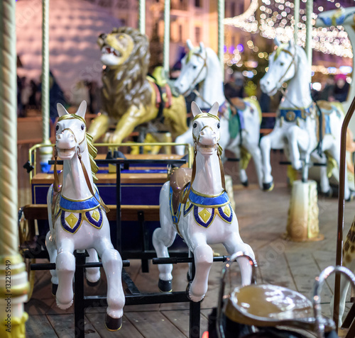 Old French carousel in a holiday park. Three horses and airplane on traditional fairground vintage . Merry-go-round with .