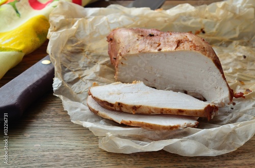 Chicken fillet whole and sliced on parchment paper