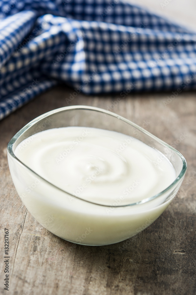Greek yogurt in glass bowl on wooden table
Greek yogurt in glass bowl on wooden table