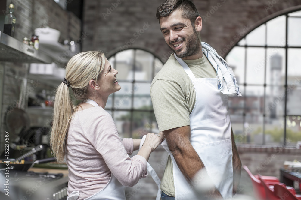 Happy couple cooking together in kitchen Happy couple cooking together in kitchen