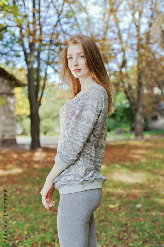 Beautiful woman with blue eyes standing in a park in autumn Beautiful woman with blue eyes standing in a park in autumn