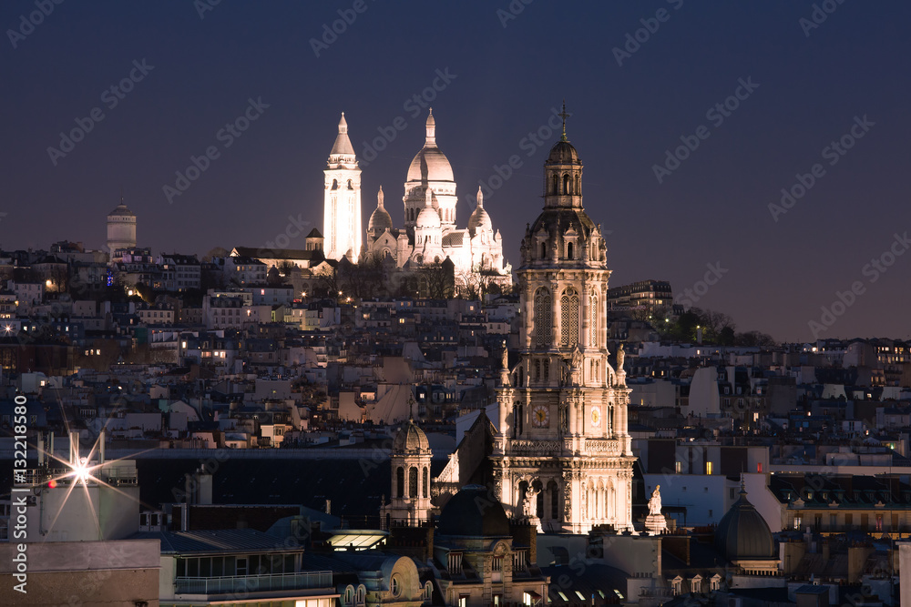 Fototapeta premium Aerial view of Sacre-Coeur Basilica or Basilica of the Sacred Heart of Jesus at the butte Montmartre and Saint Trinity church at night, Paris, France