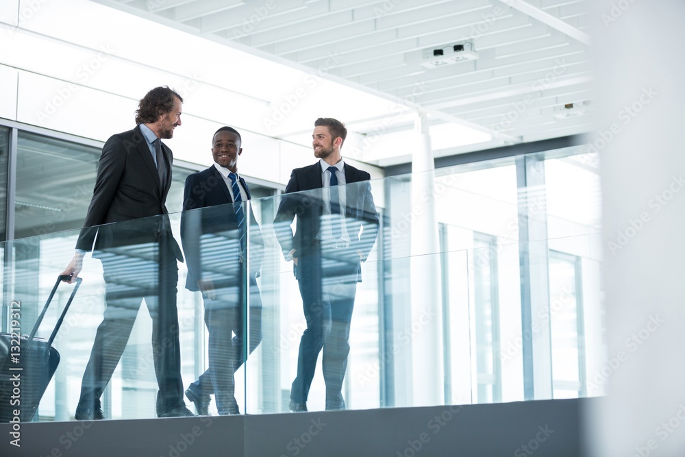 Businessman talking with colleagues while walking Businessman talking with colleagues while walking