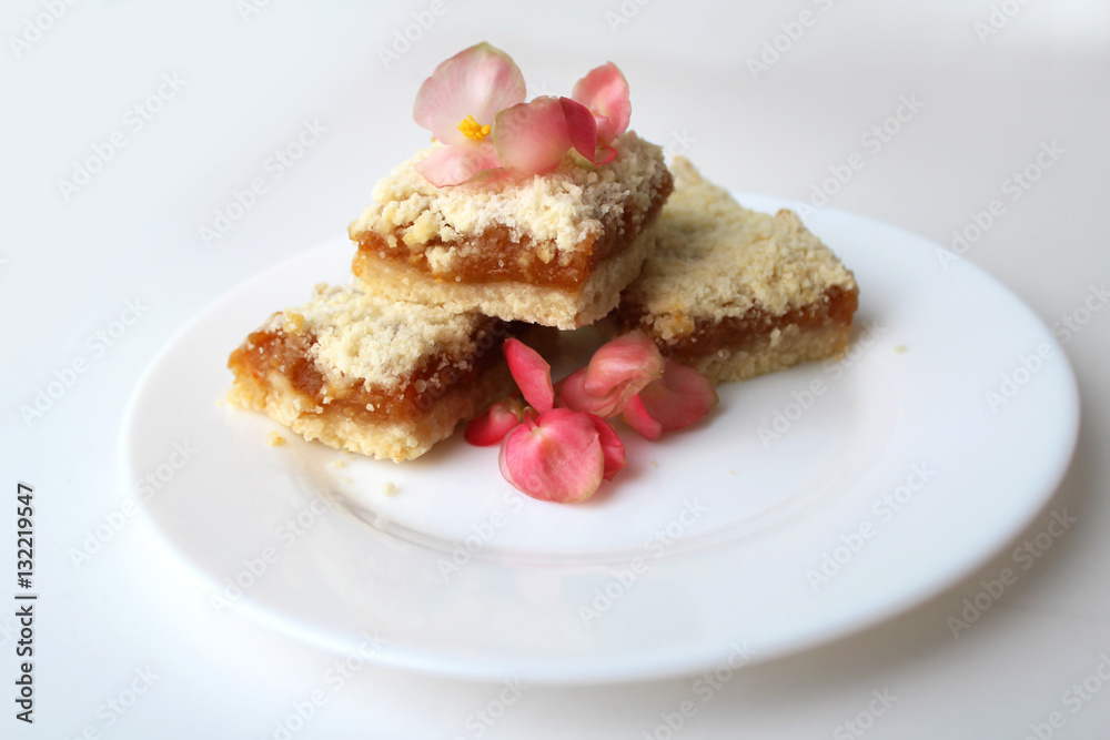 Homemade baking. Appetizing biscuits with pink flowers on a plate Homemade baking. Appetizing biscuits with pink flowers on a plate