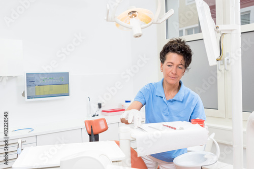 Zahnarzthelferin bereitet konzentriert den Behandlungsraum vor