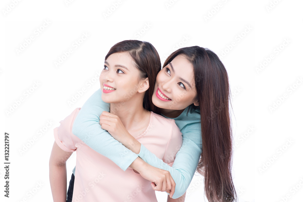 Two young asian girlfriends in hoodies having fun together. Whit Two young asian girlfriends in hoodies having fun together. Whit