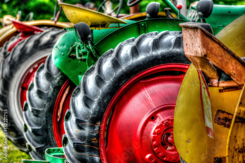Close up photograph of a row of old tractors at a rural farm auction