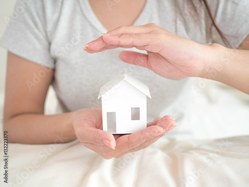 Woman protect house in her hand