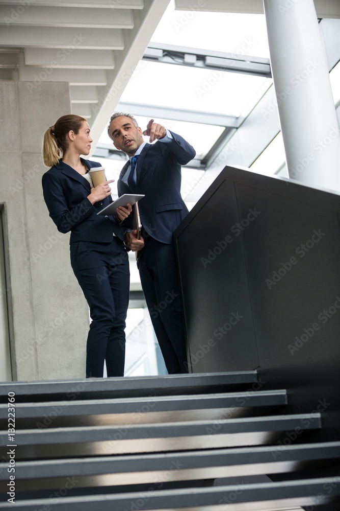 Business colleagues standing on a staircase Business colleagues standing on a staircase