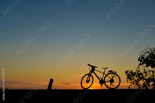 Silhouette of bicycles on the road with the sunset background.