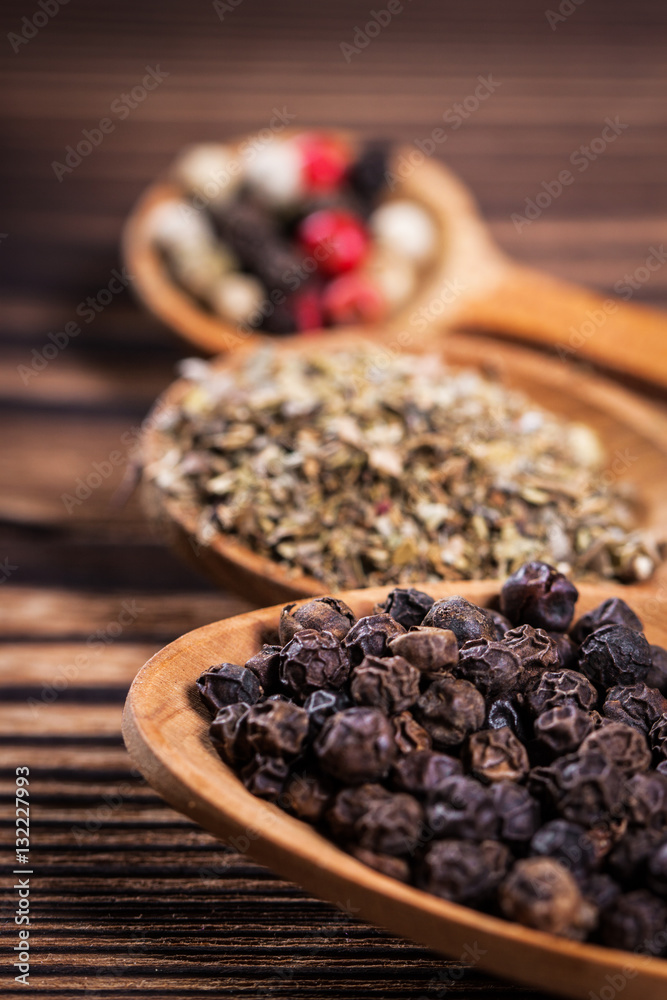 Spices close up in a spoon on a wooden table Spices close up in a spoon on a wooden table