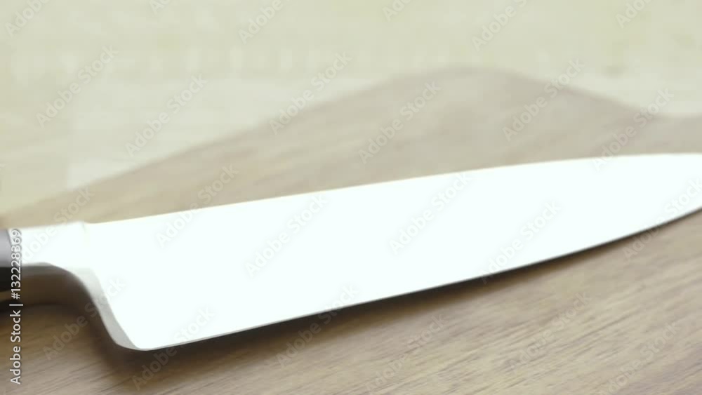 Sliced zucchini on wooden cutting board. Food preparation film clip. Concept of vegetarian cooking.