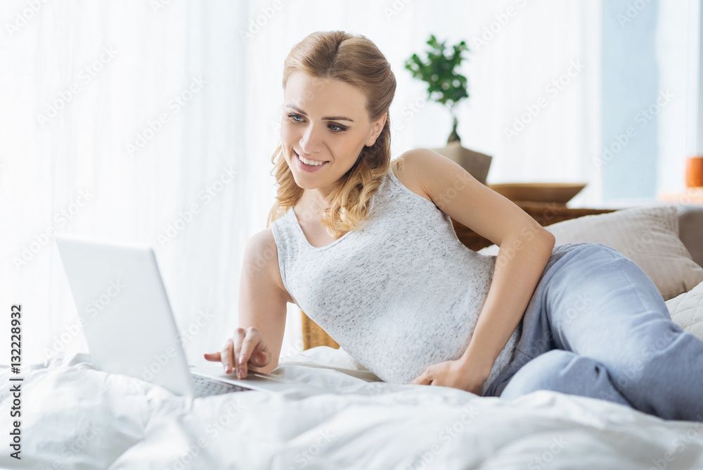 Relaxed pregnant woman using laptop in bedroom Relaxed pregnant woman using laptop in bedroom