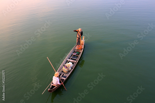 Fototapeta Two Burmese fishermen are fishing on a boat