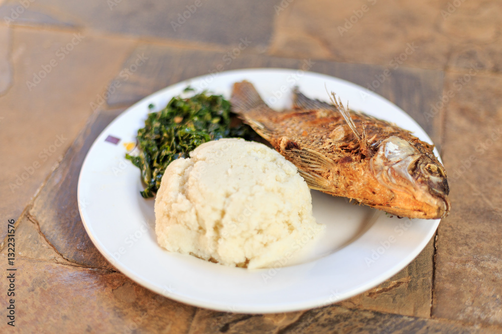 Traditional african food - ugali, fish and greens Traditional african food - ugali, fish and greens