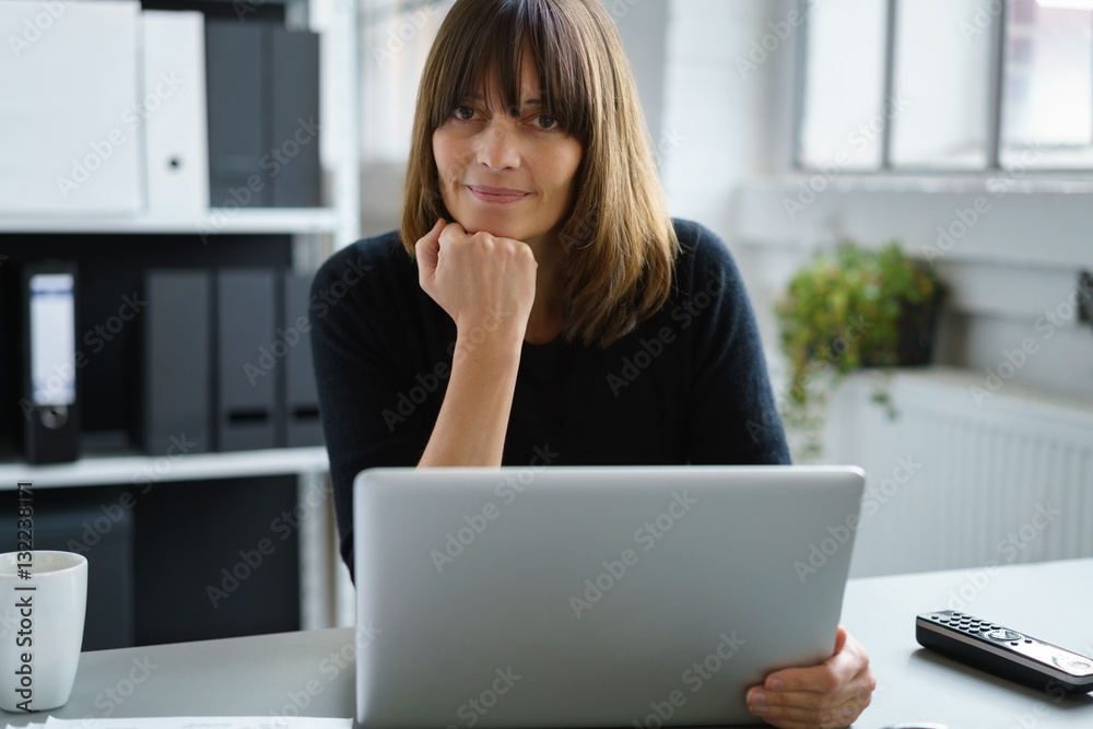 frau arbeitet mit laptop am schreibtisch frau arbeitet mit laptop am schreibtisch
