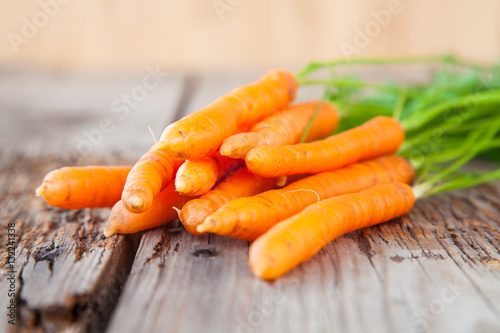 carrots with a tops of vegetable on a table, selective focus