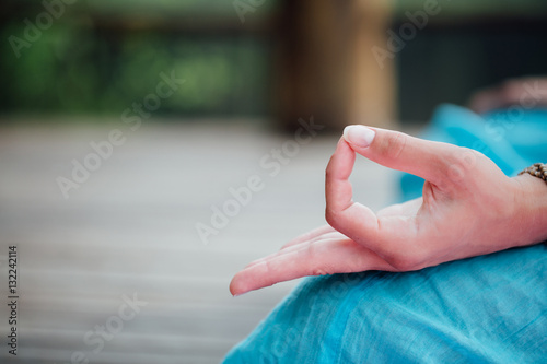 Woman meditating in the lotus position closeup. Hands close-up.