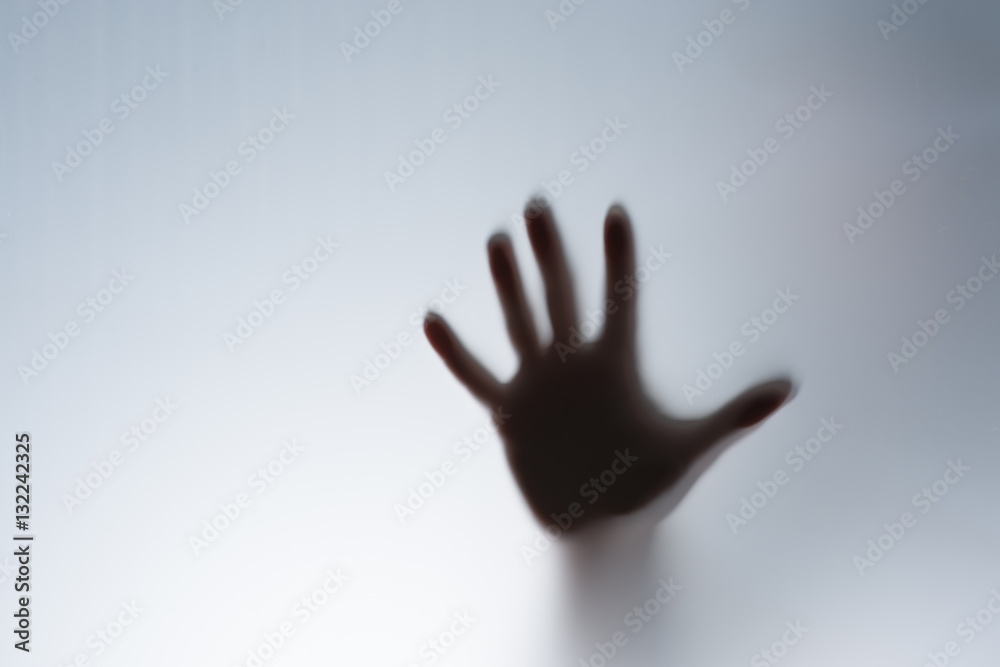 Silhouette of a hand behind the glass