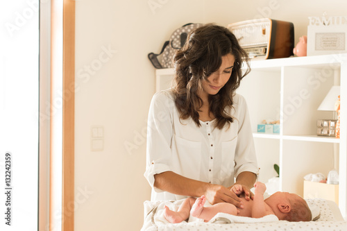 Mother changing baby's diaper