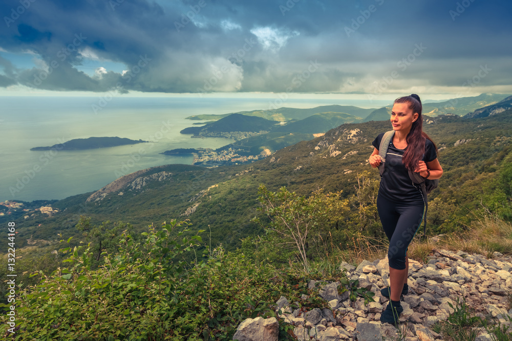 Hiker with backpack  on top of a mountain. Achievement in mountains. Freedom and active life concept.