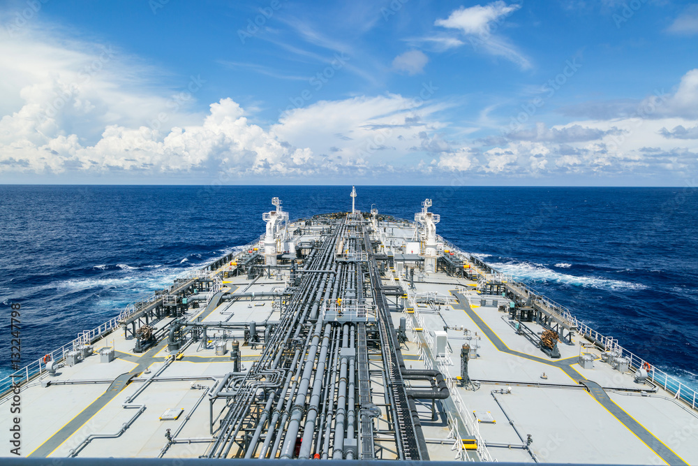 Obraz premium Grey oil tanker in calm blue ocean.