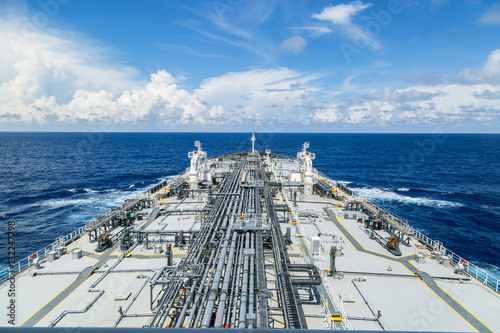Grey oil tanker in calm blue ocean.