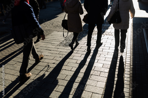 walking people with long shadows