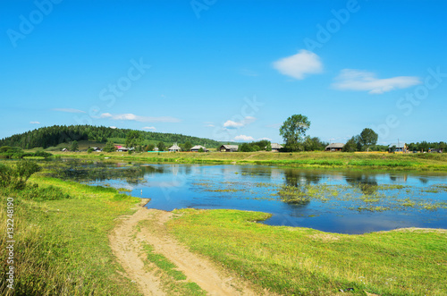 Rural landscape with village by the river